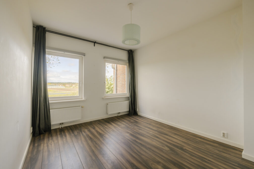 Empty room with wood floor and windows