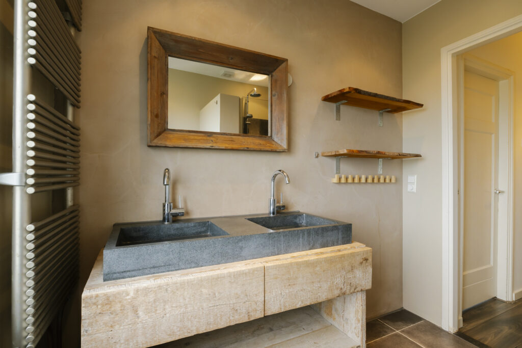 Modern bathroom with wooden vanity and large mirror.