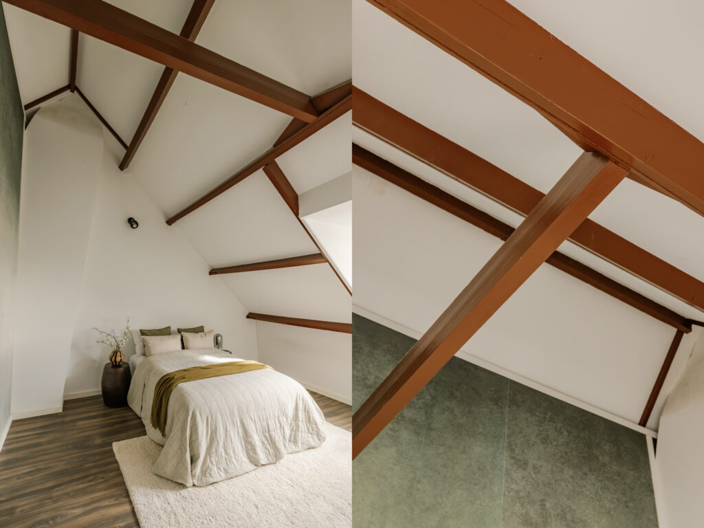 Cozy attic bedroom with wooden beams and bedding.