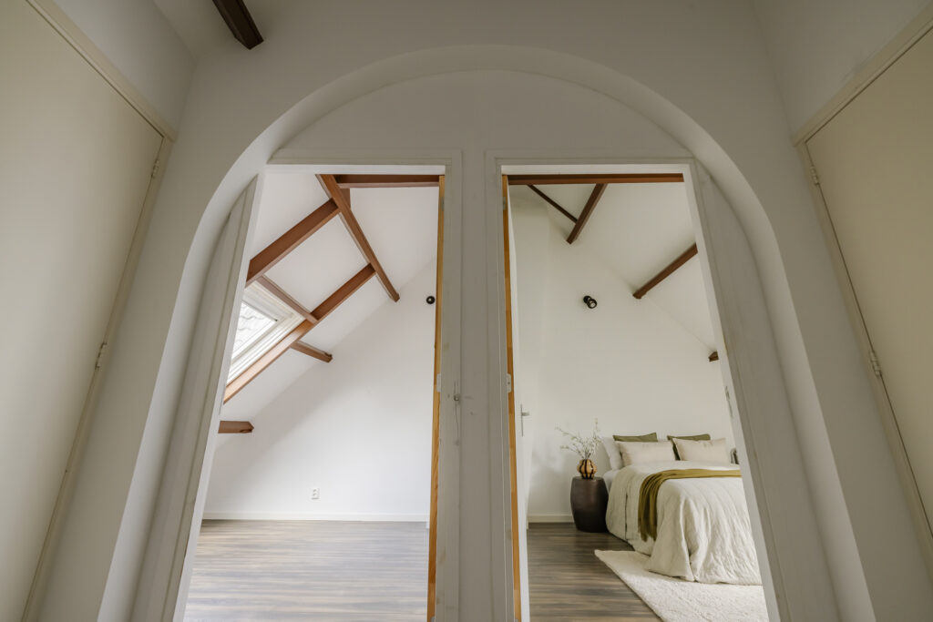 Modern attic bedroom with vaulted ceiling and decor.