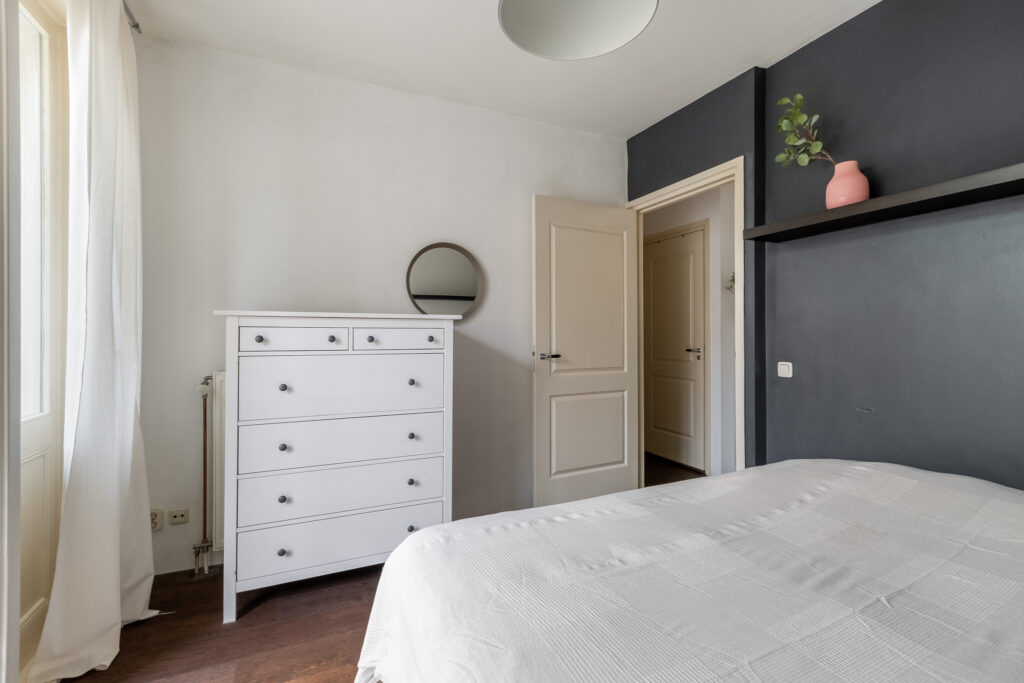 Minimalist bedroom with white dresser and bed