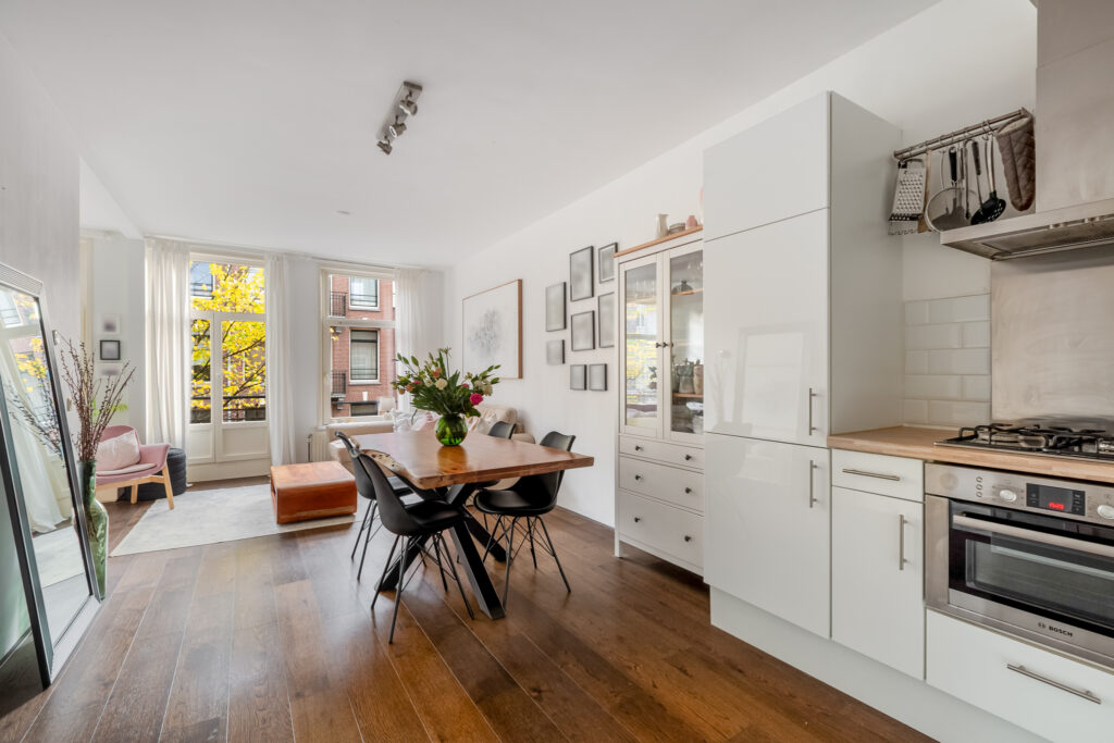 Modern kitchen and dining area with wooden floor.
