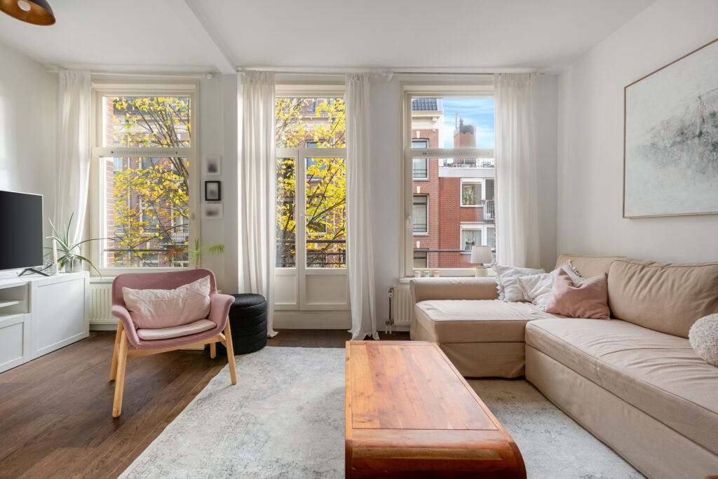 Modern living room with large windows and sofa.