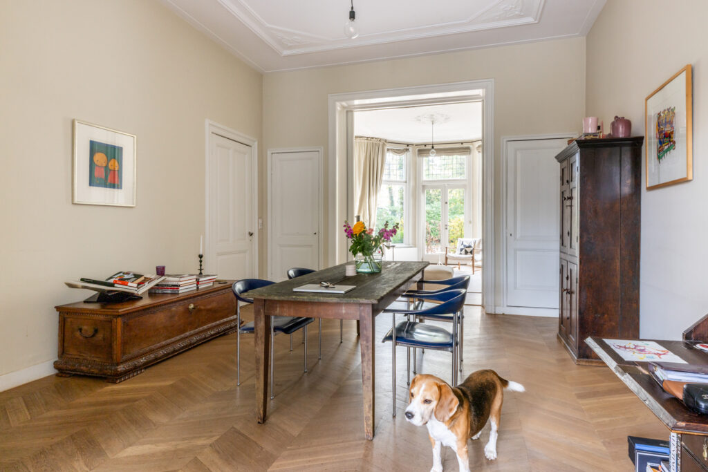 Dining room with table, chairs, and a beagle dog.