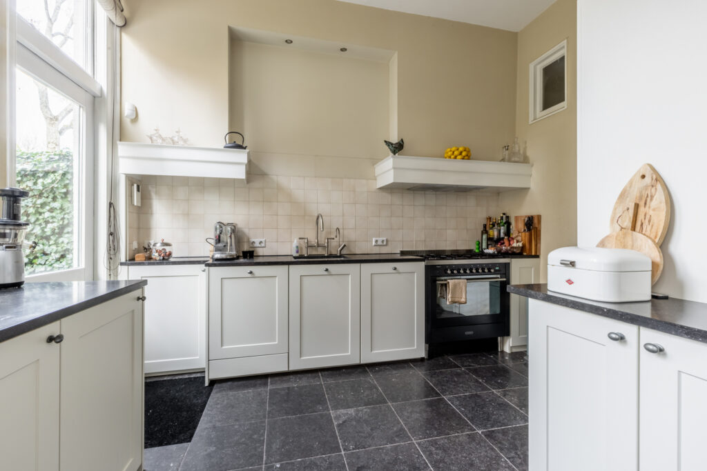 Modern kitchen with white cabinets and appliances.