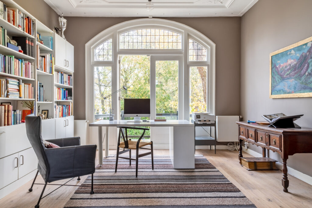 Cozy home office with large window and desk.