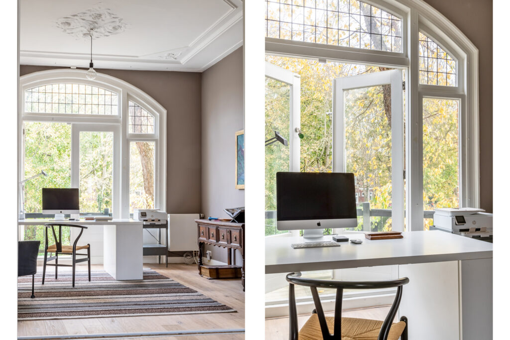 Bright home office with large windows and computer.