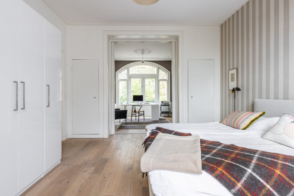 Cozy bedroom with soft natural lighting and office view.