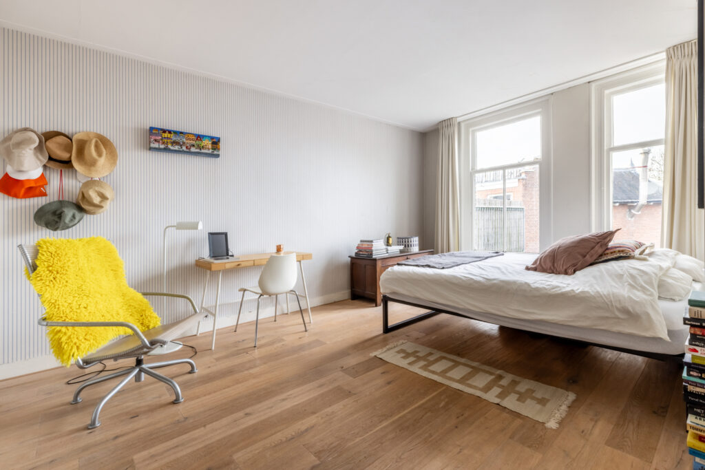 Modern bedroom with desk, bed, and chair.