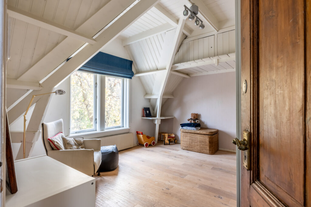 Cozy attic playroom with toys and armchair.