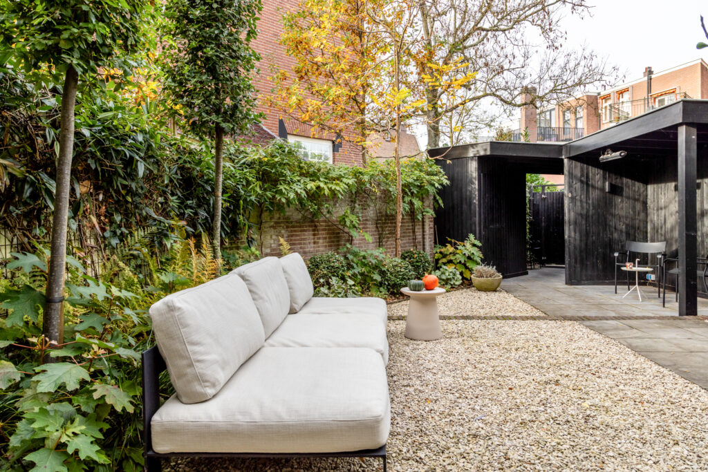 Cozy garden with sofa and black shed