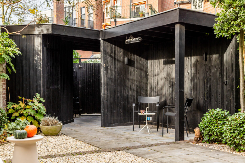 Cozy outdoor patio with chairs and plants.