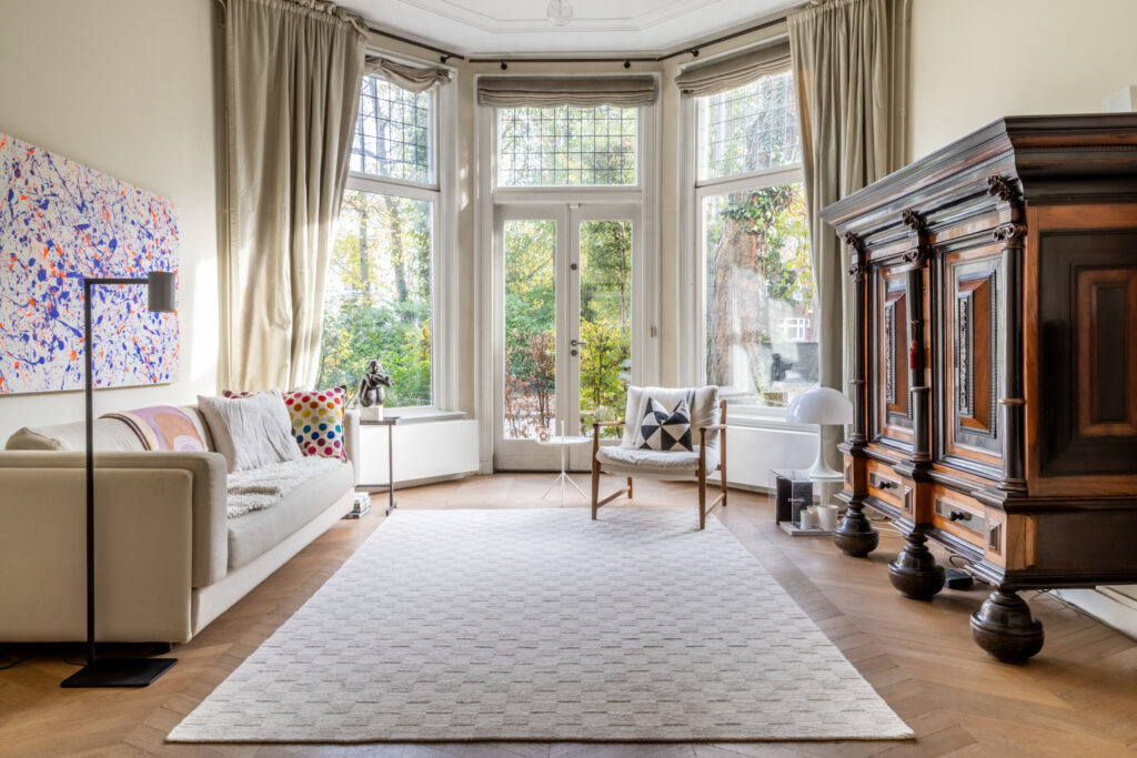 Spacious living room with large windows and modern decor.