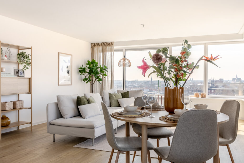 Modern living room with city view and dining setup.