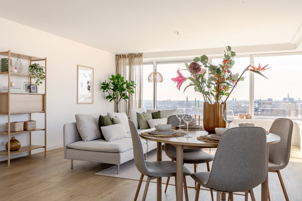 Modern living room with city view and dining set.