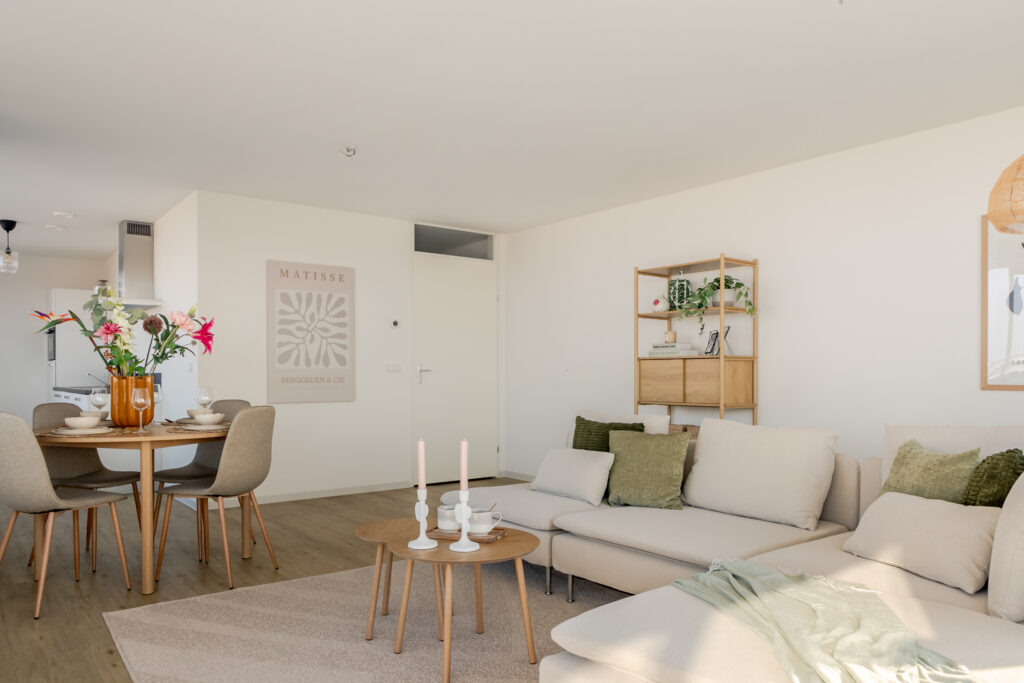 Modern living room with beige couch and dining set.