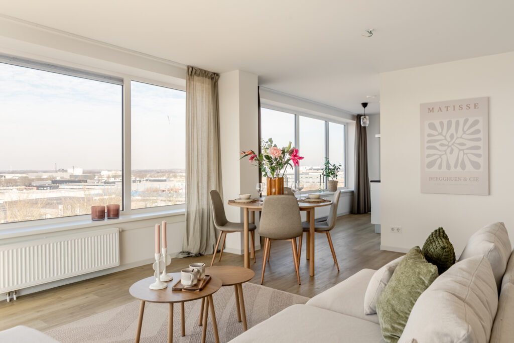 Modern living room with dining area and city view.