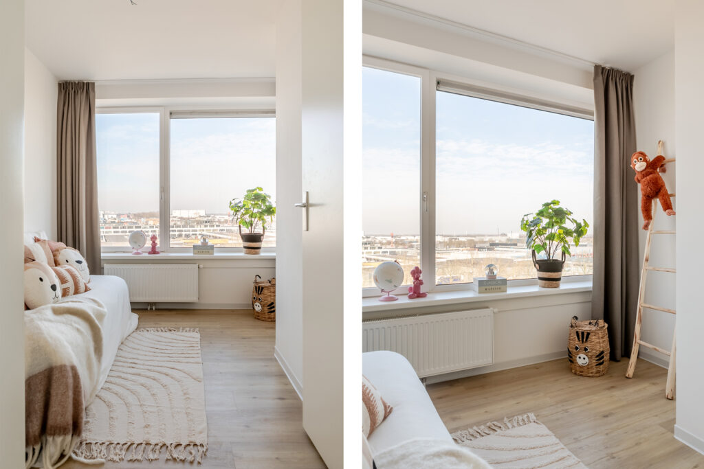 Cozy kid's room with stuffed toys and window view.