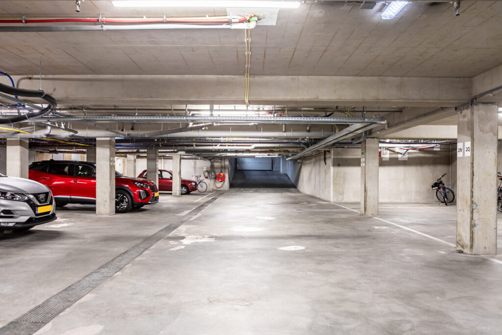 Underground parking garage with cars and bicycles.