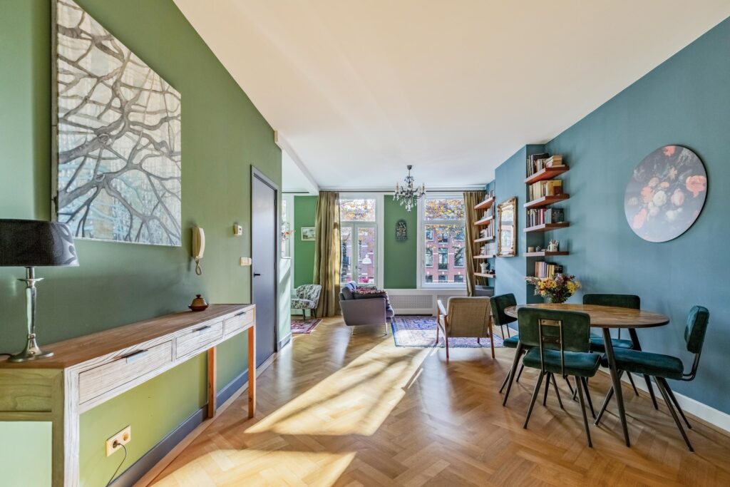 Modern open-concept living and dining room with green walls.