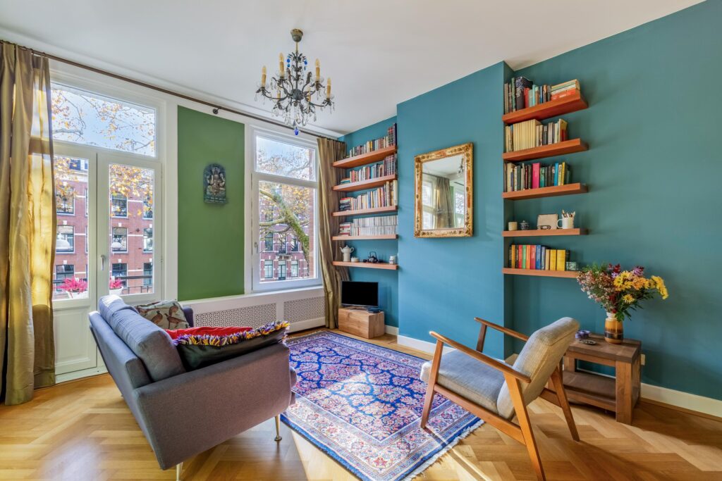 Cozy living room with bookshelf and colorful rug.