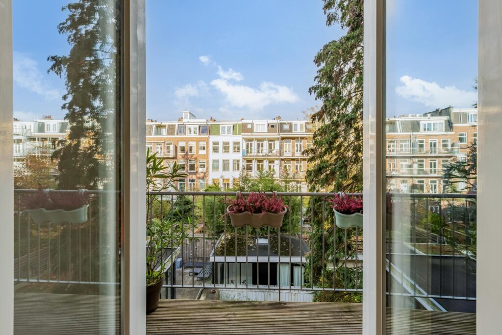 City balcony view with plants and buildings.