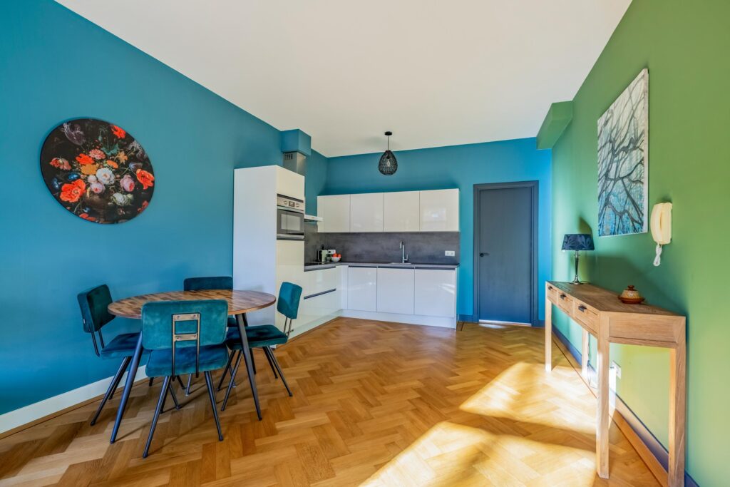 Modern kitchen-dining area with vibrant wall colors.