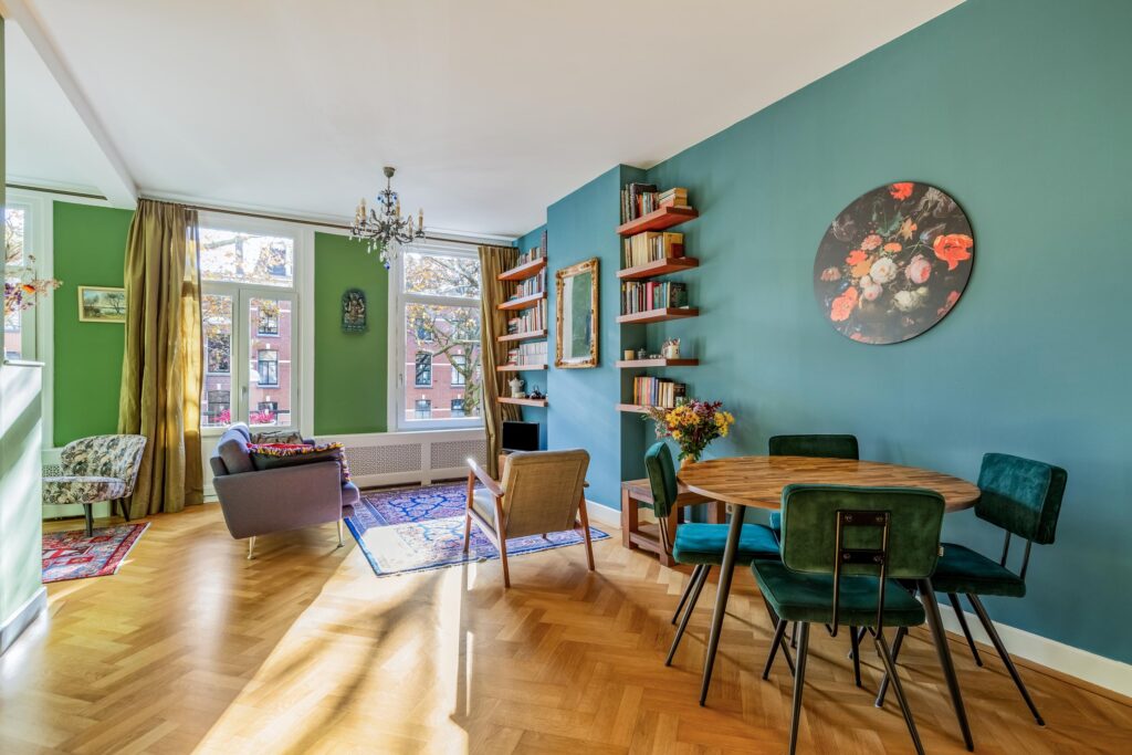 Cozy living room with green walls and wood floors.