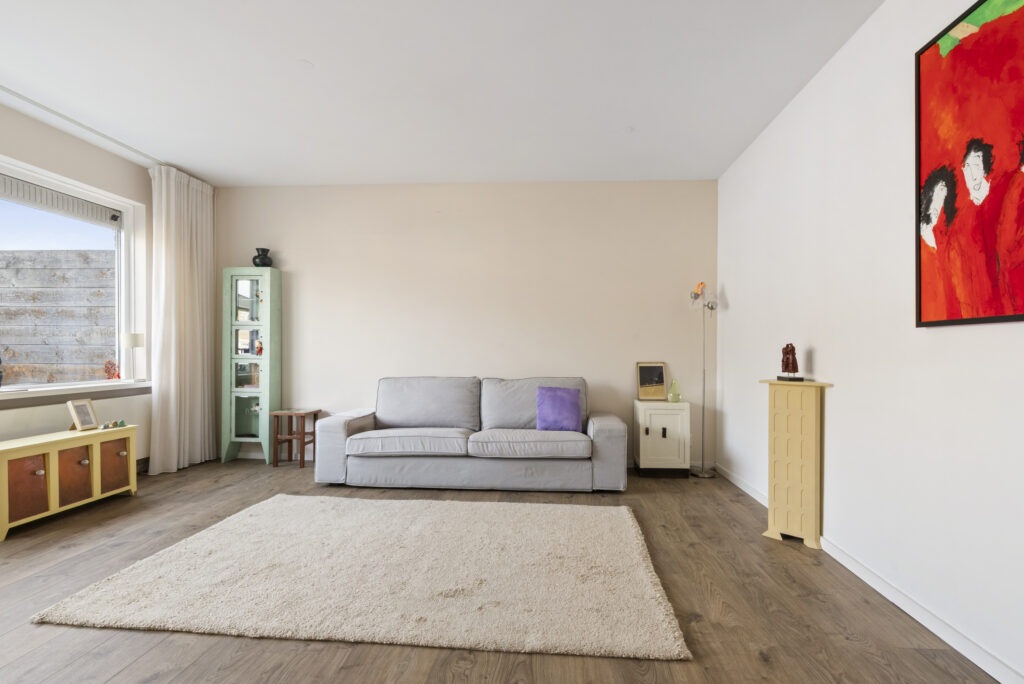 Modern living room with gray sofa and colorful art.
