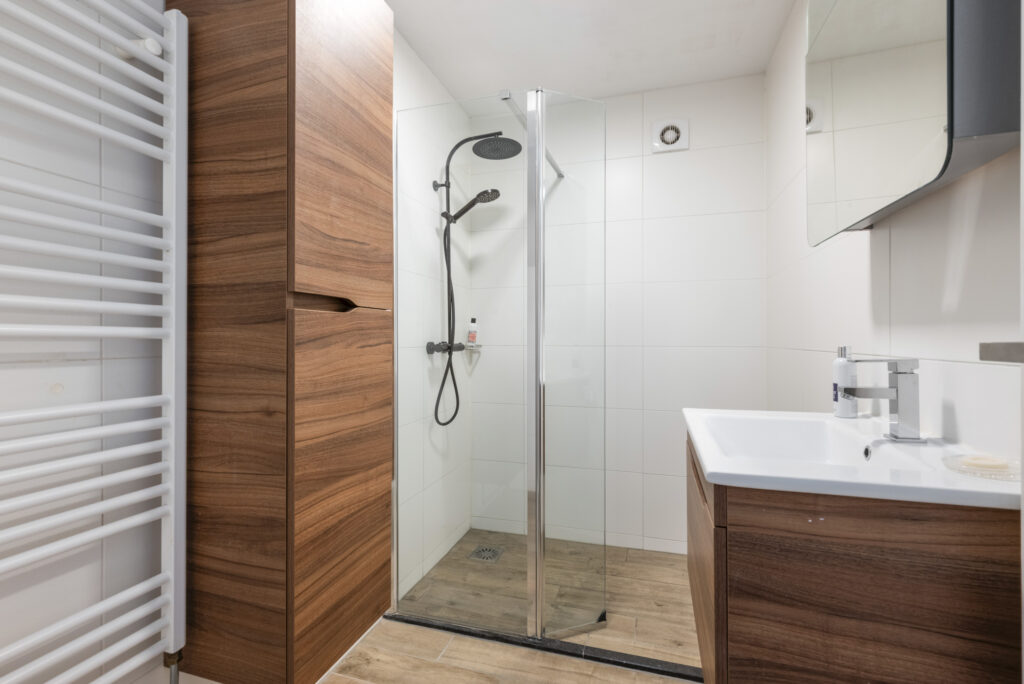 Modern bathroom with wooden cabinets and glass shower
