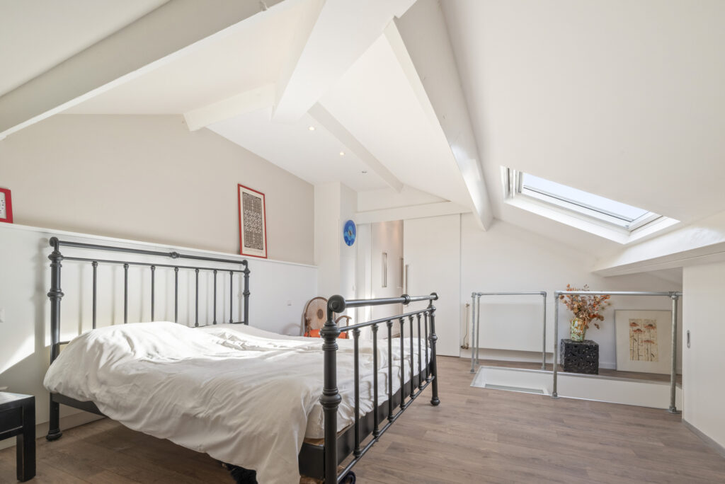 Loft bedroom with skylight and modern decor