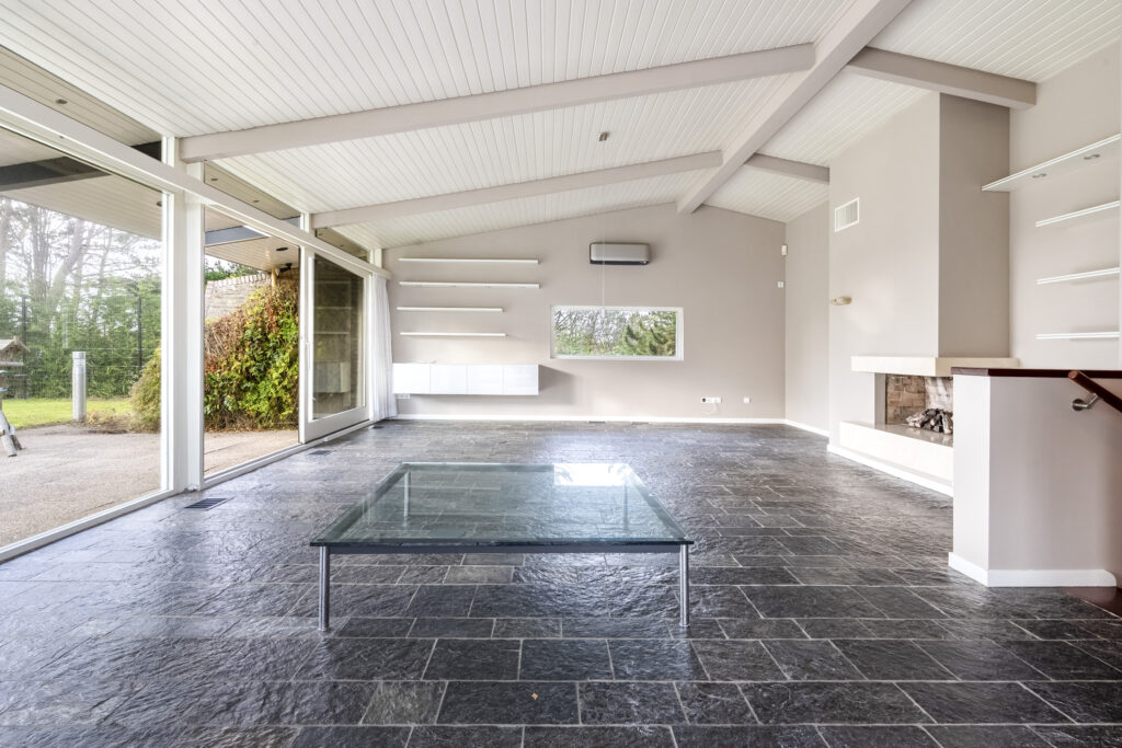Spacious modern living room with glass table.