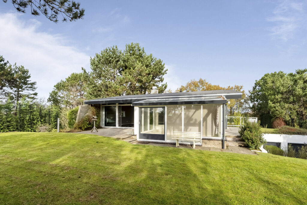 Modern house surrounded by greenery and trees.