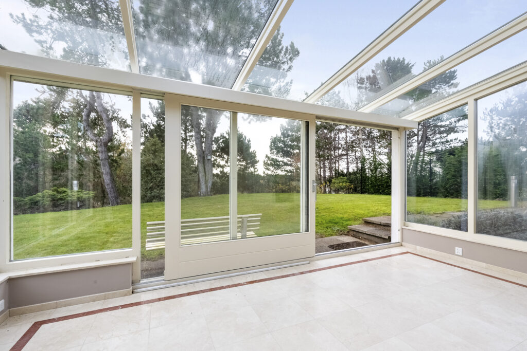 Bright sunroom overlooking lush green backyard