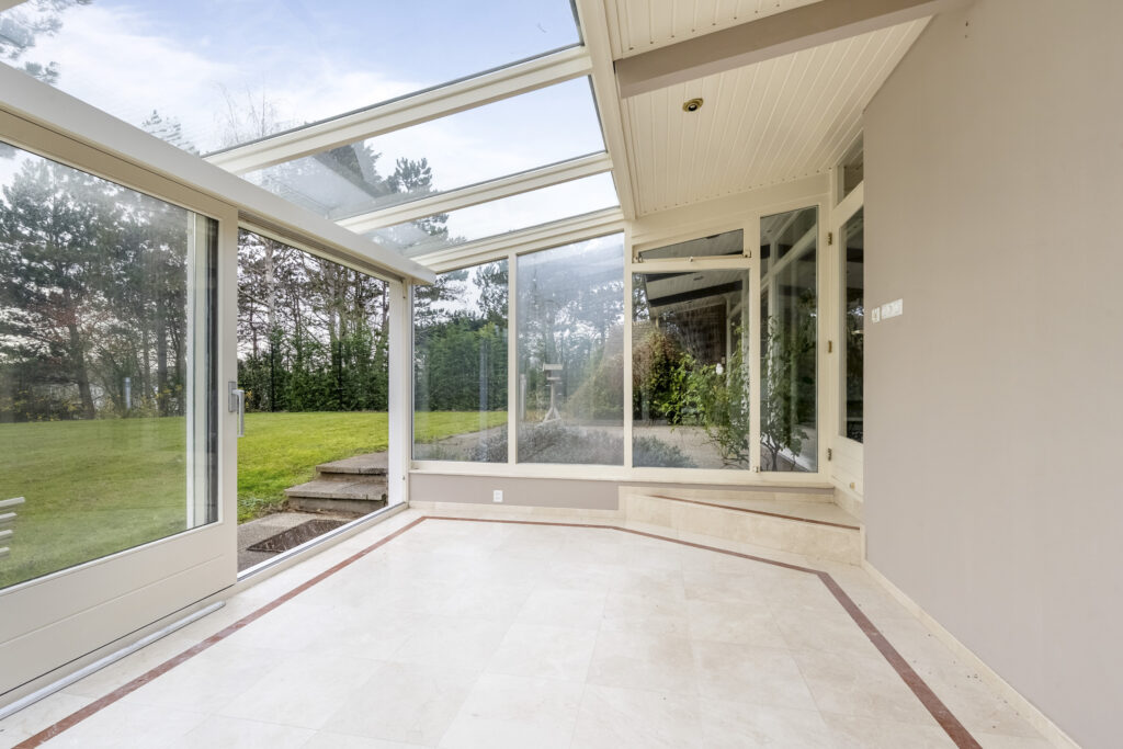 Bright sunroom with large windows and garden view.