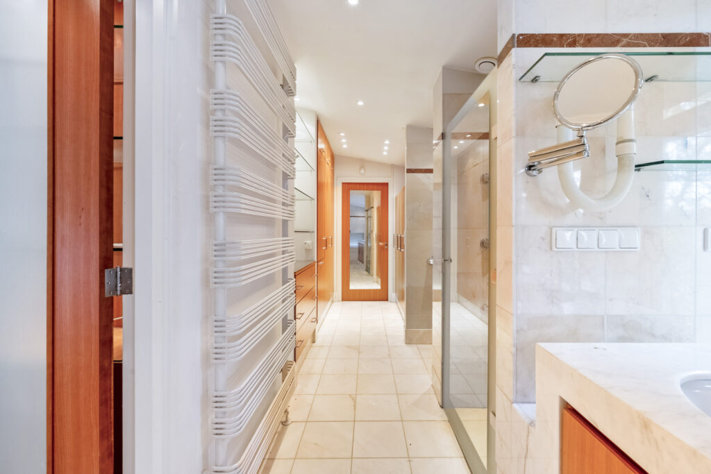 Spacious modern bathroom with wooden accents and mirrors.