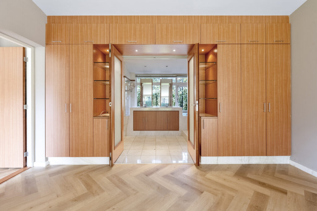 Spacious room with wooden cabinets and chevron flooring.