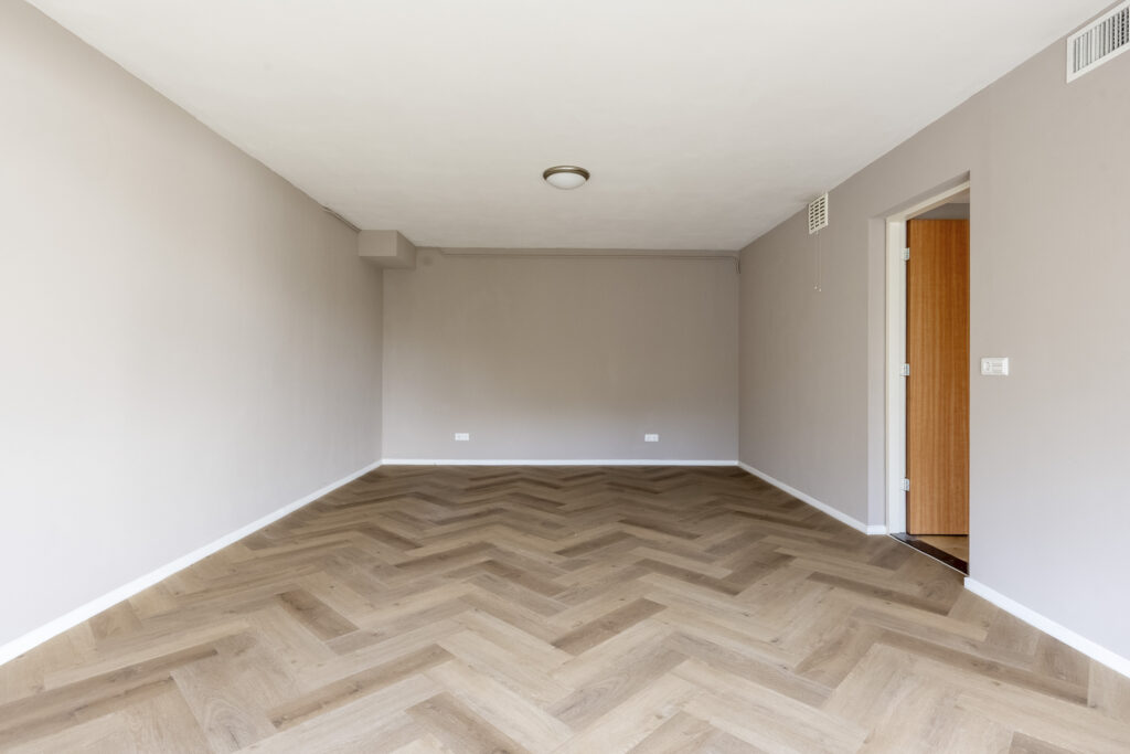 Empty room with wooden herringbone floor