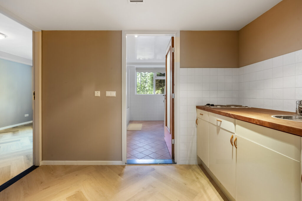 Modern kitchen with wooden accents and tiled floor.