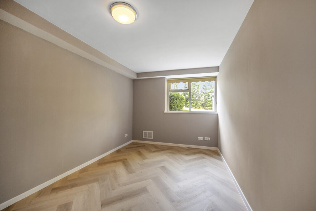 Empty room with wooden flooring and window