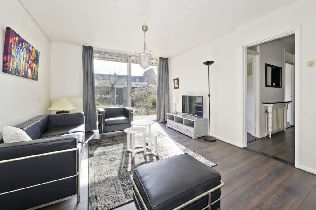 Modern living room with black furniture and TV.