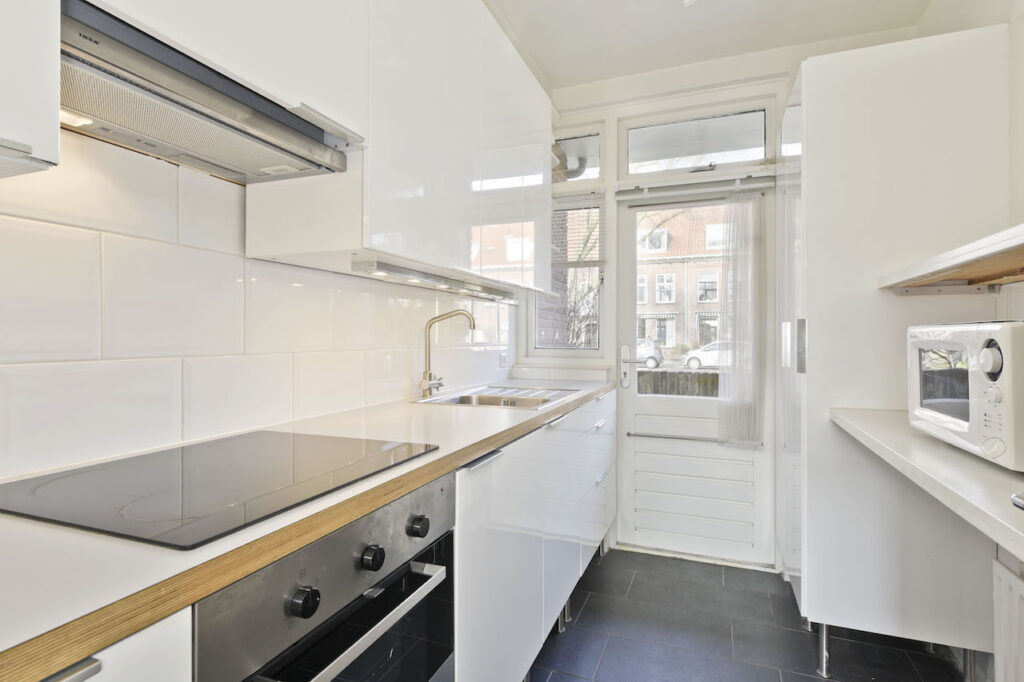 Modern kitchen with white cabinets and appliances.