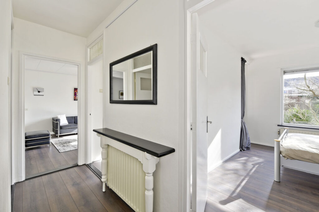 Bright hallway with doors to bedroom and living room.