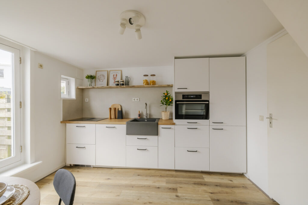 Modern kitchen with white cabinets and wooden counters.