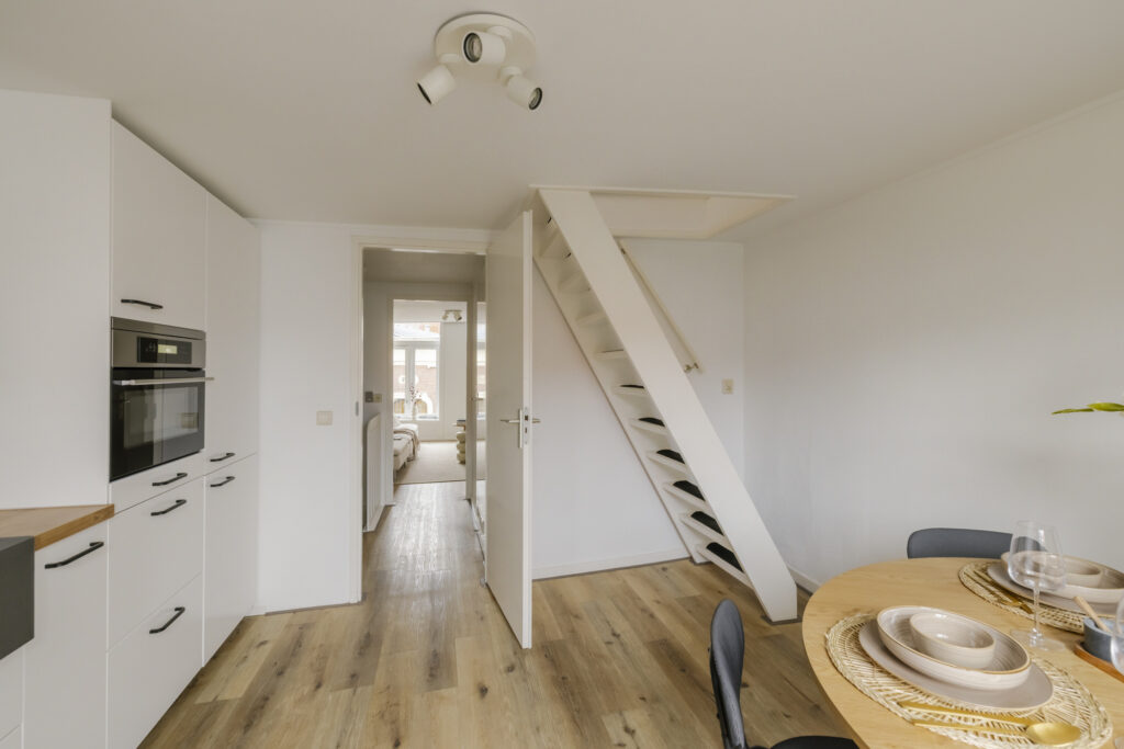 Modern kitchen with wooden floors and dining area.