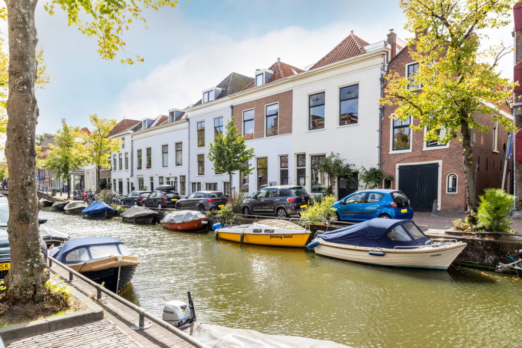 Canal view with boats and European houses.