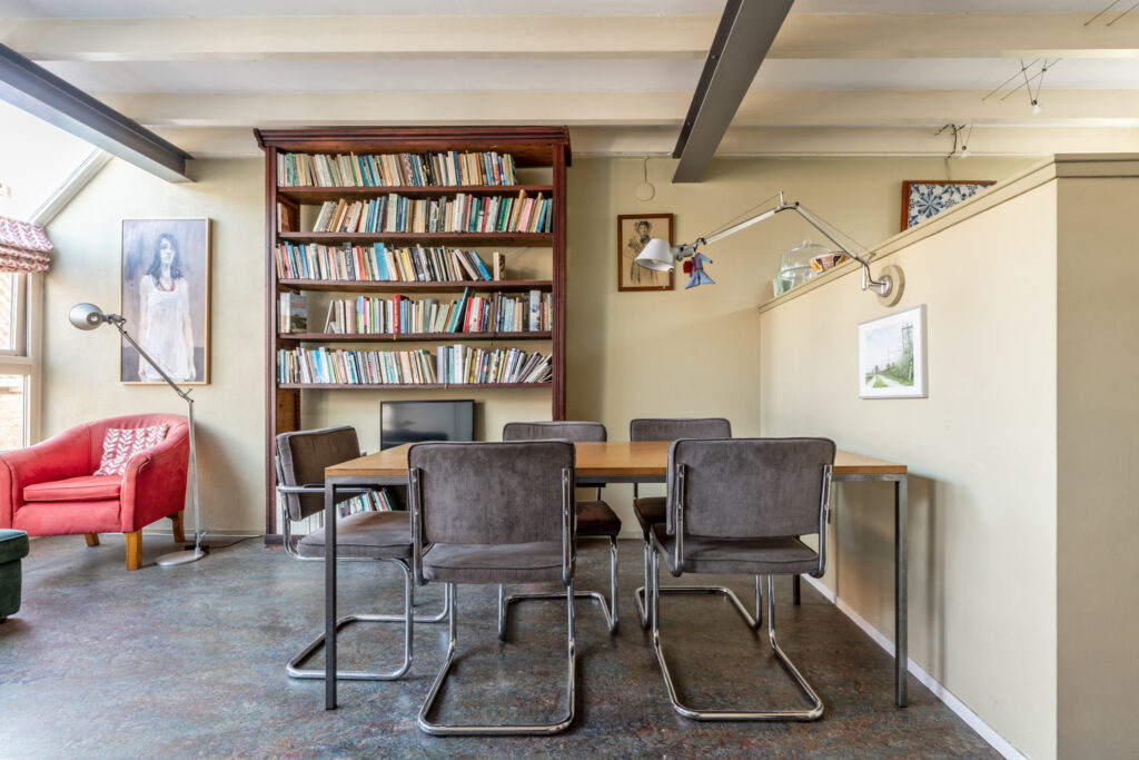 Cozy reading nook with bookshelf and table.