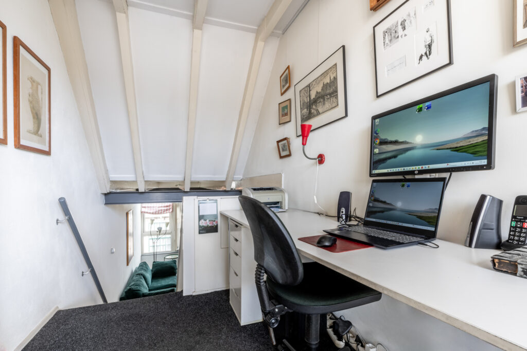 Cozy home office with computer and art.