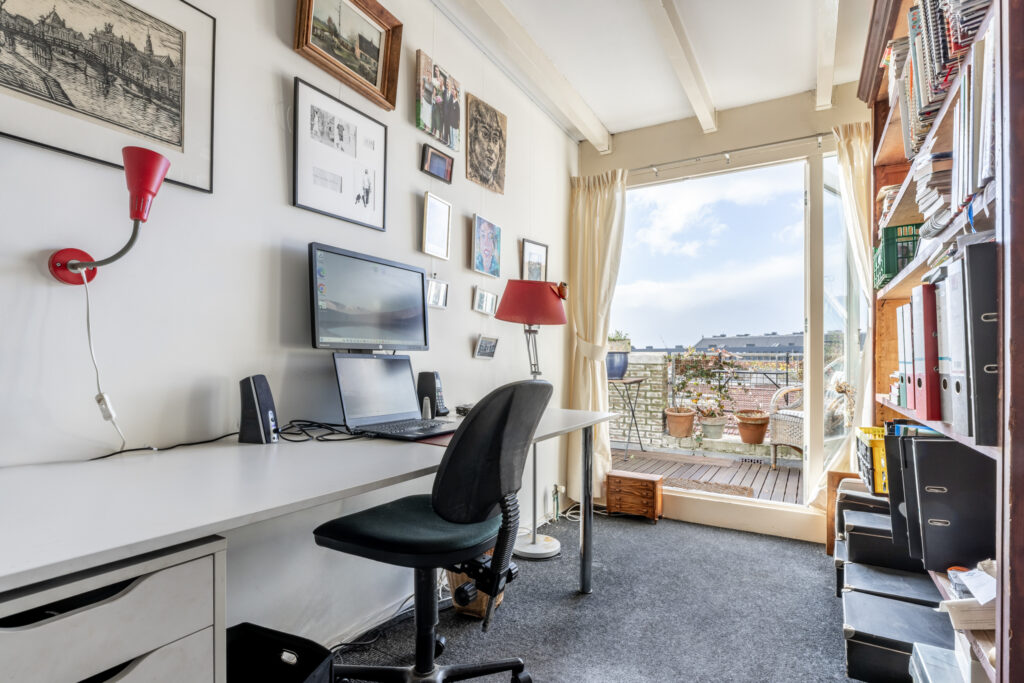 Home office with computer, desk, and garden view.