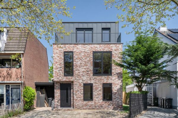 Modern brick house with large windows and trees.